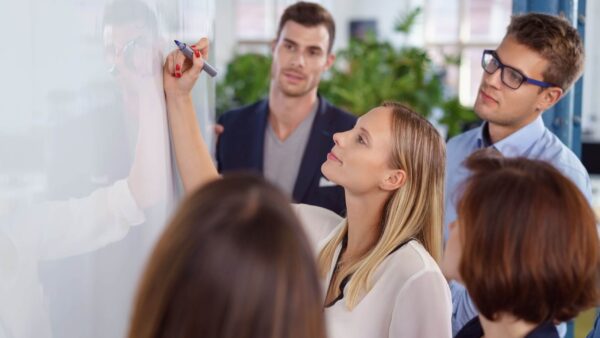 Ausbilder schreibt beim AEVO Inhouse-Seminar an ein Whiteboard.