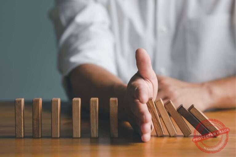 aevo online - konflikte ausbildung | aevo online eine hand stoppt fallende dominosteine um einen konflikt zu symbolisieren