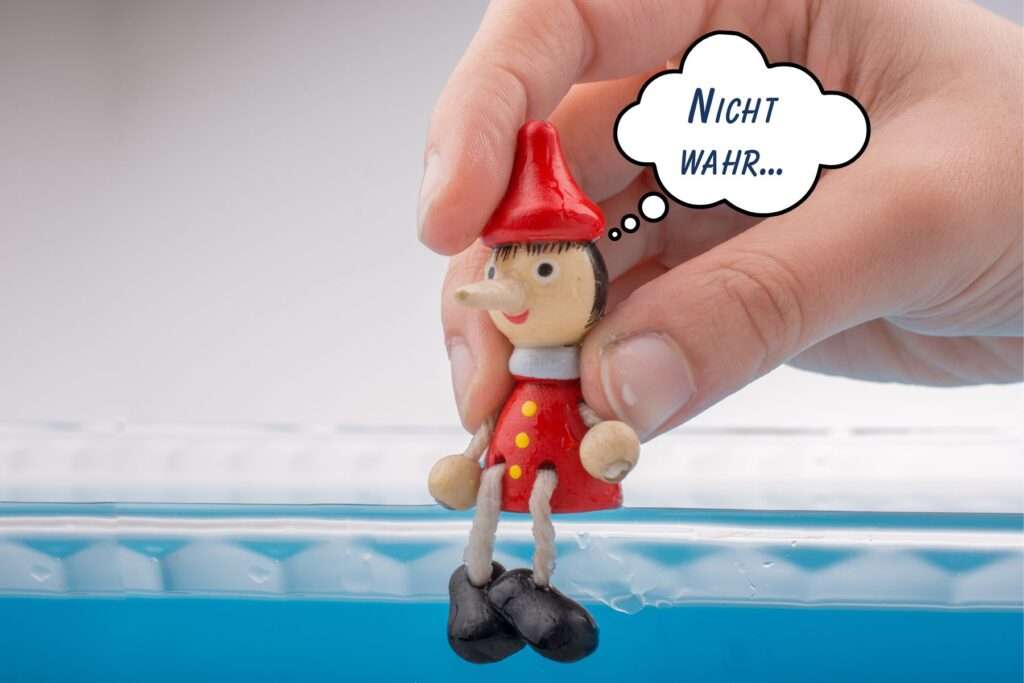 sitzende holzpuppe mit langer nase als symbol wenn azubis lügen