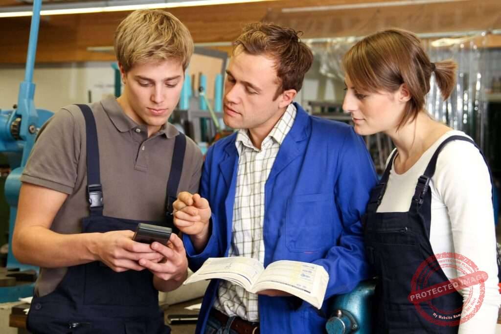 ausbilder mit azubis in werkstatt